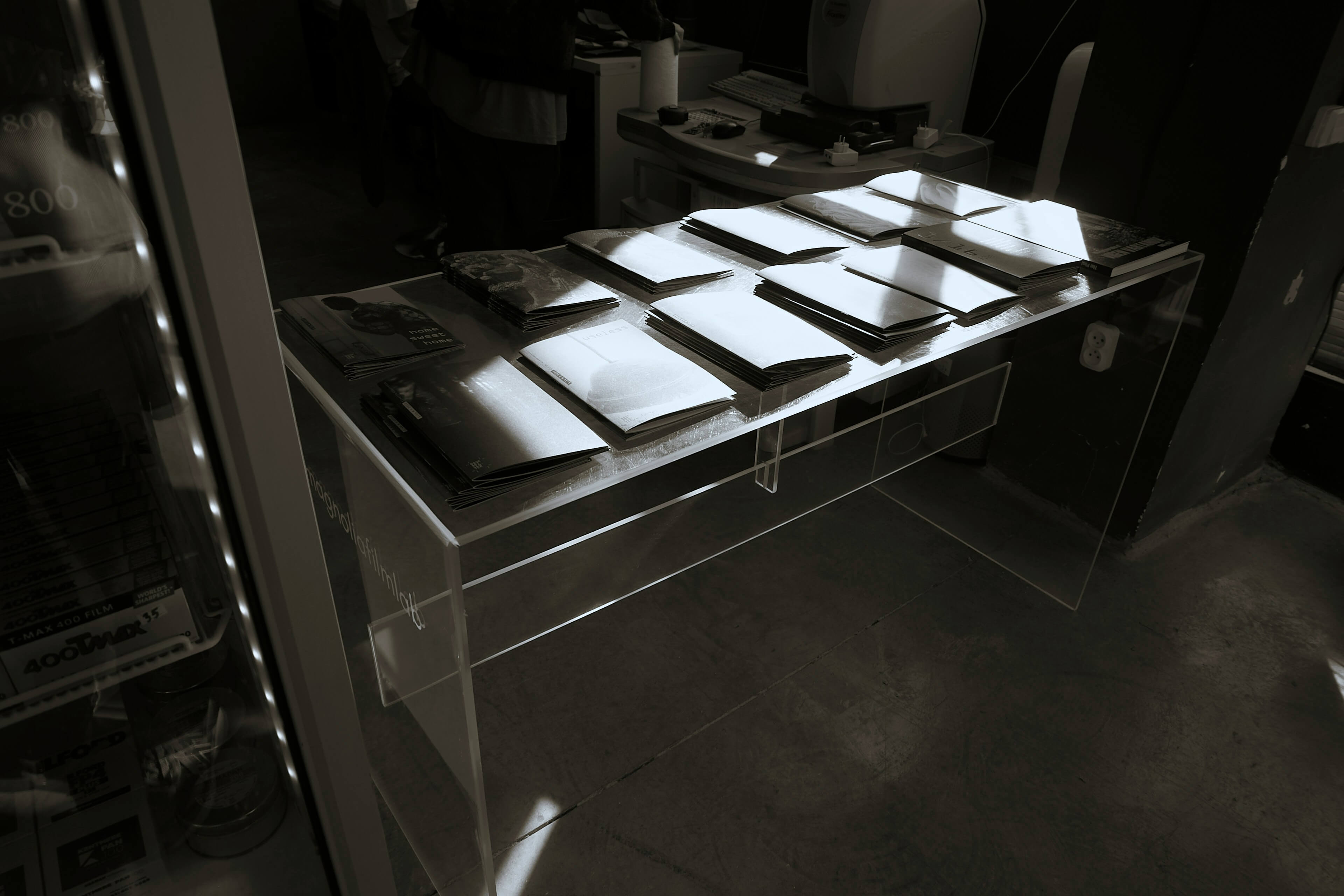 A dimly lit back room with a long table covered in file folders, suggesting the behind-the-scenes scoring room of sorority recruitment.
